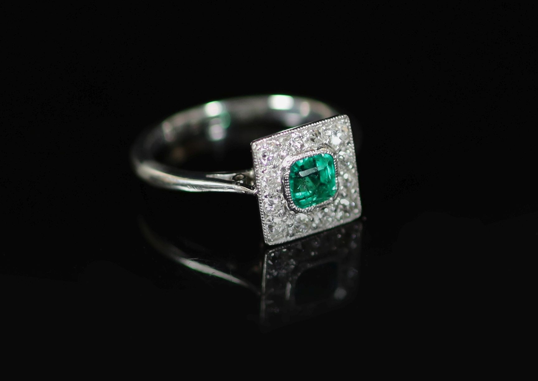 A 1920's platinum, emerald and diamond cluster set tablet ring